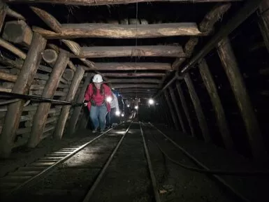 groupe de visiteurs grimpant le plan de la galerie du Puits des Glénons