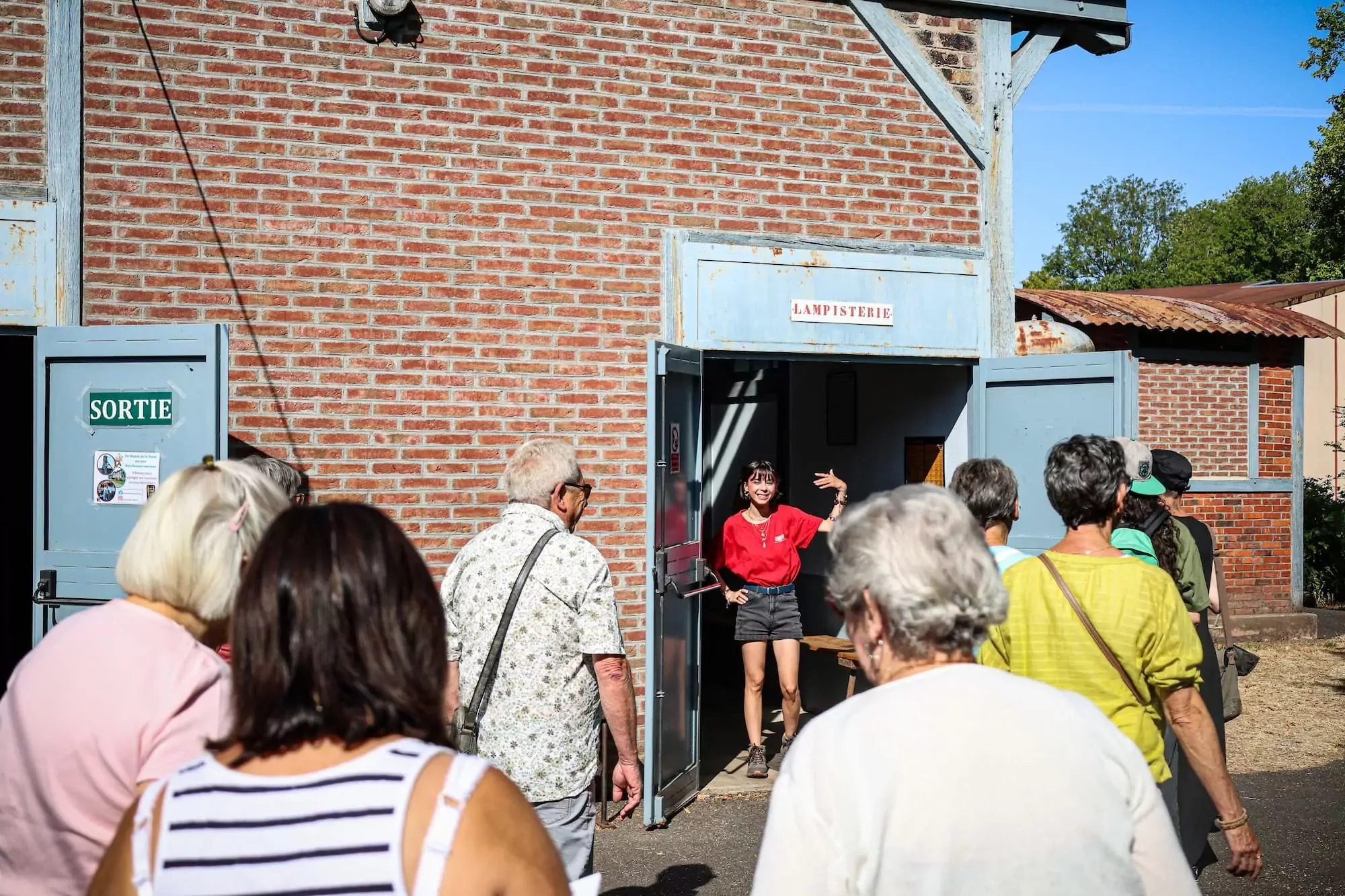 guide qui demande aux visiteurs de rentrer dans la lampisterie